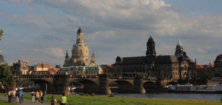Blick vom Elbufer in der Inneren Neustadt unterhalb der Augustusbrücke auf die historische Innenstadt, in der Mitte die Augustusbrücke, über dieser hell mit grünem Kupferdach die Sekundogenitur, dahinter die Frauenkirche, rechts das Neue Ständehaus mit Turm, dahinter der Turm des neuen Rathauses am Altmarkt, rechts von der Augustusbrücke am Elbufer der Theaterkahn